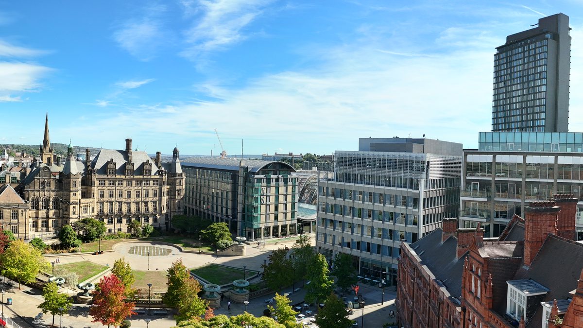 Aerial view over a city centre square with a hotel, cafes and a town hall